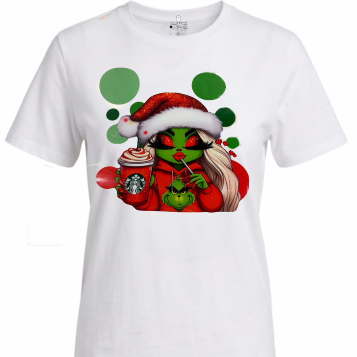 A white short-sleeve crewneck t-shirt featuring a colorful graphic print of a green-skinned woman in a red Santa hat and red sweater, holding a Starbucks coffee cup.