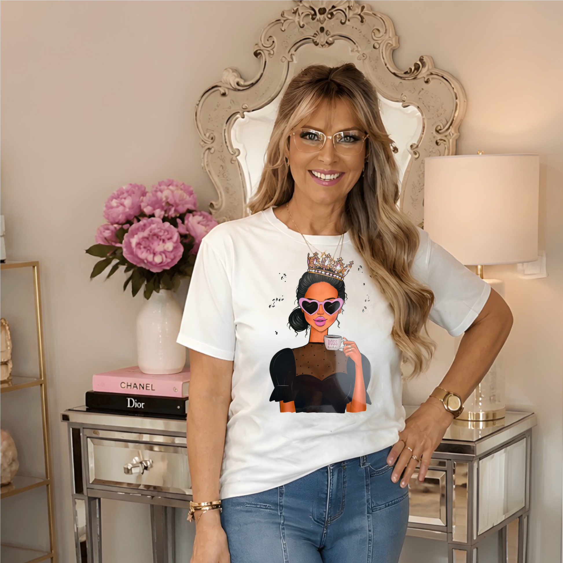  a white graphic t-shirt featuring a cartoon illustration of a woman in sunglasses and a crown