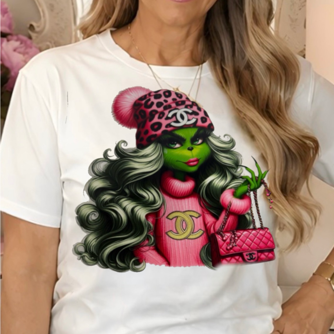 a white graphic t-shirt with a colorful print of a female Grinch cartoon character.