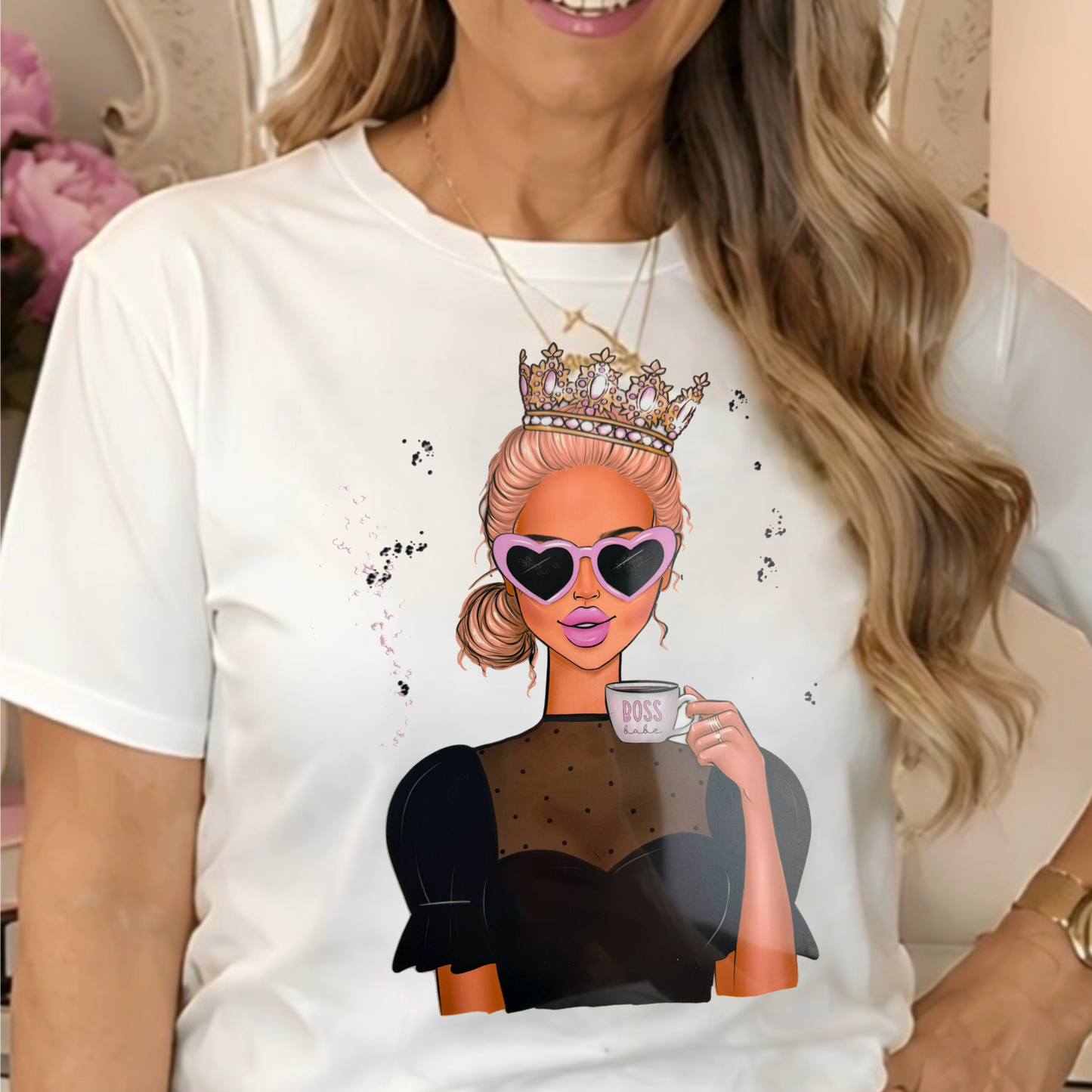a white graphic t-shirt with a cartoon illustration of a woman in a crown and sunglasses