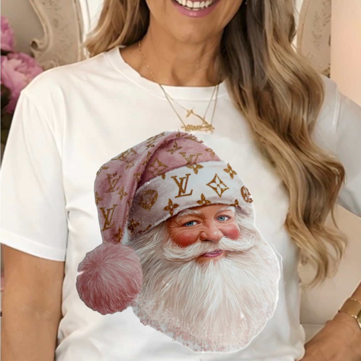 a white graphic t-shirt featuring a large print of Santa Claus wearing a pink and gold LV hat.